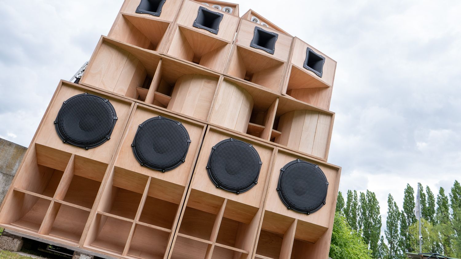 Detail van de houten kasten: bashoorns onderaan, ronde luidsprekers in het midden, hoorns bovenaan